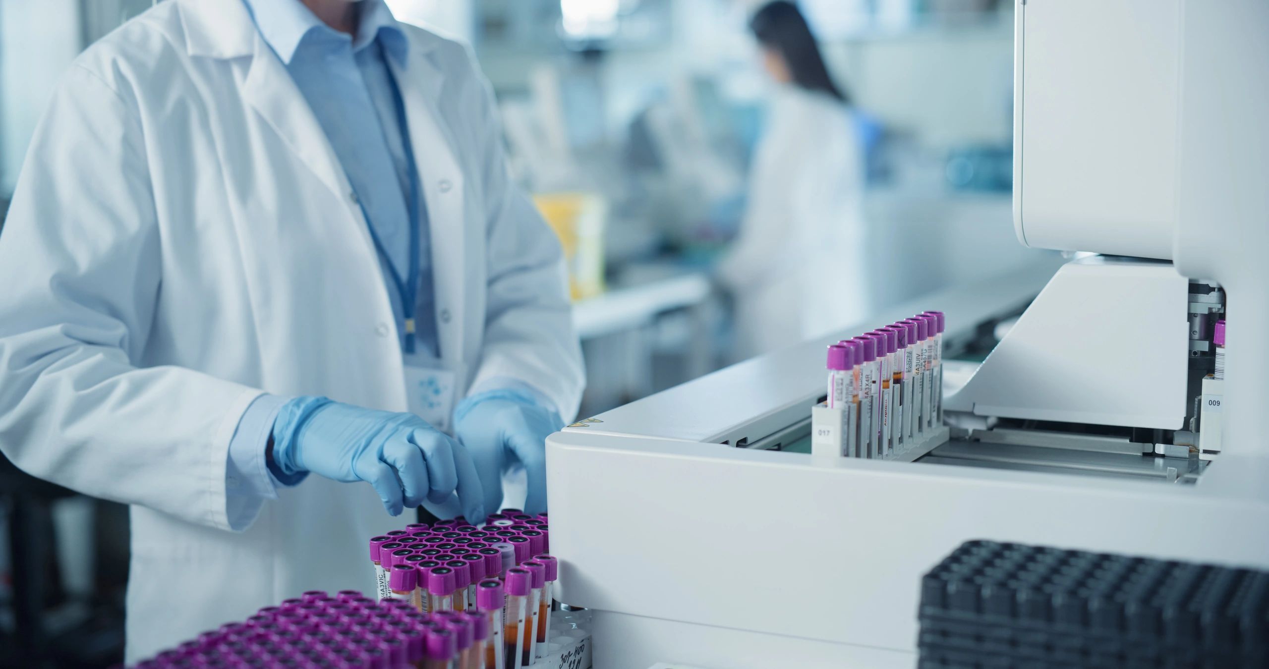 Laboratory technician processing clinical samples with diagnostic equipment